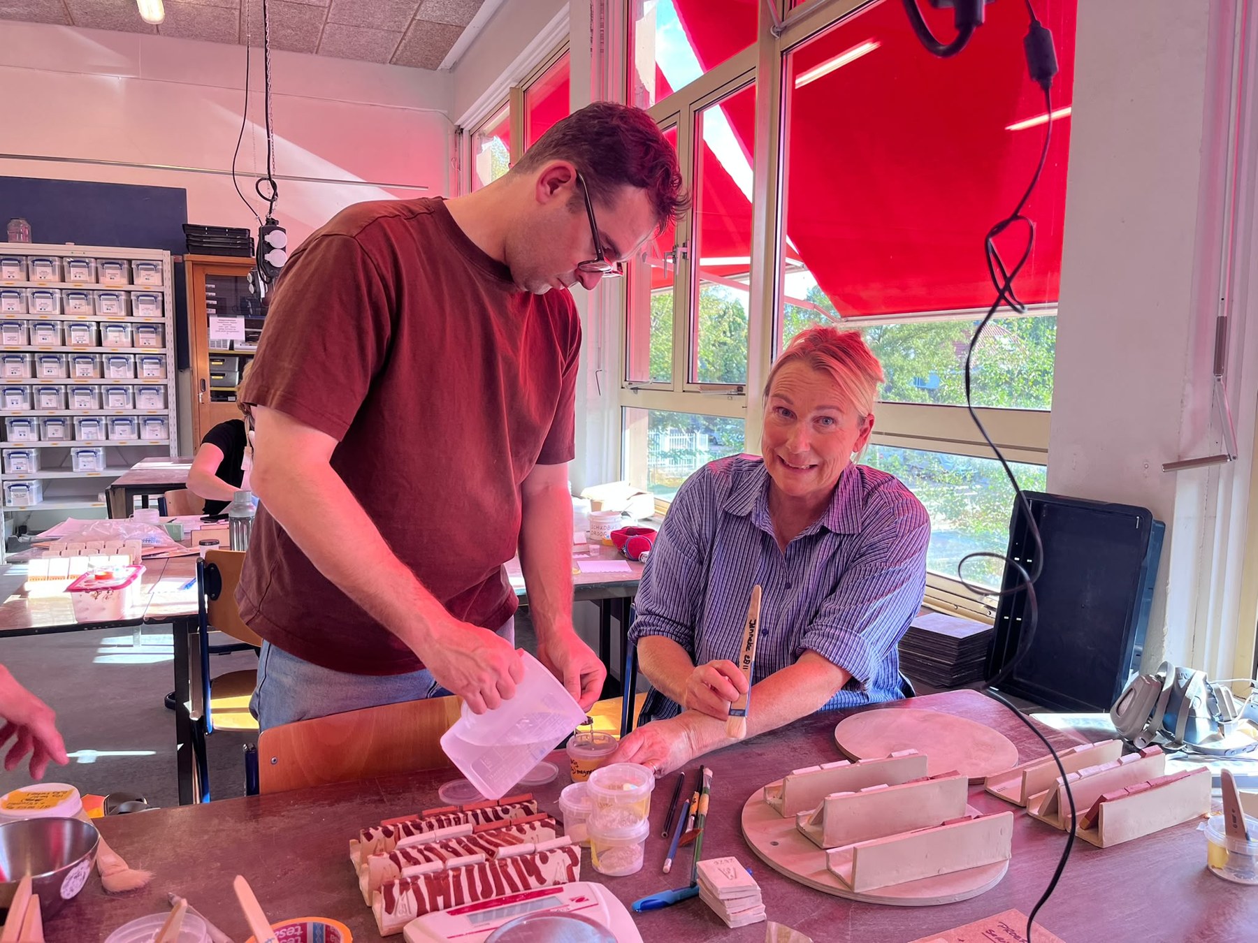 Michael working alongside another maker at a studio table